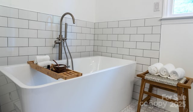 full bath with a freestanding bath and tile walls