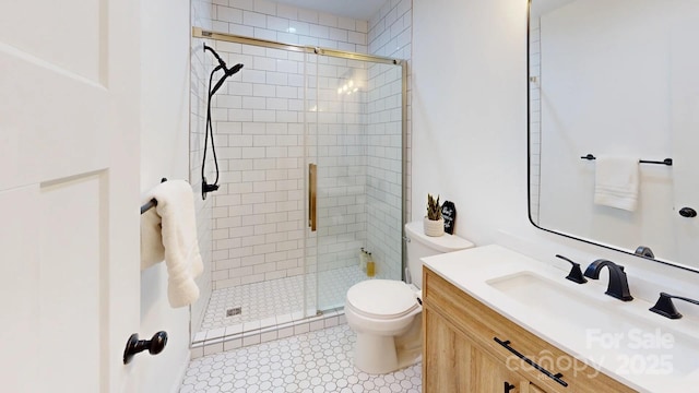 bathroom featuring toilet, a shower stall, and vanity