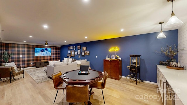 dining room featuring light wood-style flooring, an accent wall, baseboards, and recessed lighting