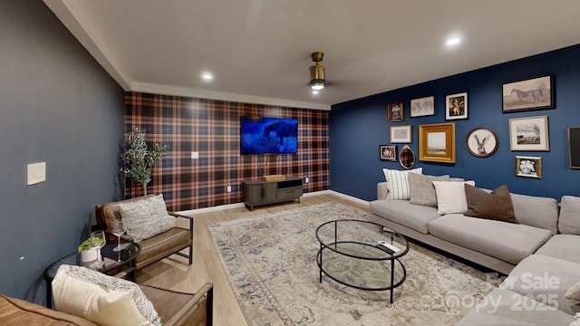 living area featuring wallpapered walls, baseboards, an accent wall, wood finished floors, and recessed lighting