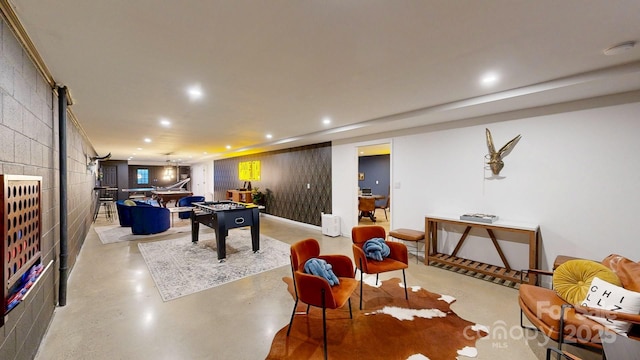 recreation room featuring recessed lighting and finished concrete flooring