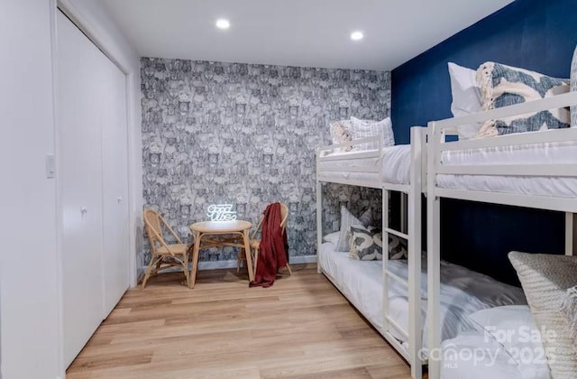 bedroom featuring an accent wall, recessed lighting, light wood-style flooring, and wallpapered walls