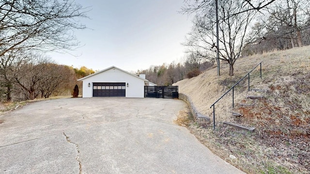 view of home's exterior featuring a garage, fence, and stucco siding