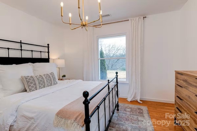 169 Chandler Rd, Alexander, NC 28701 - bedroom with a chandelier, wood finished floors, and baseboards