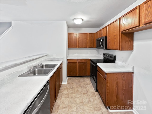 kitchen featuring stainless steel appliances, brown cabinetry, a sink, and light countertops