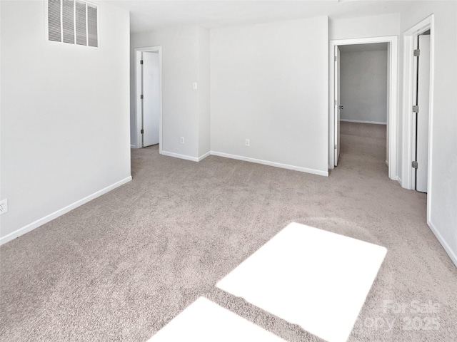 carpeted spare room with visible vents and baseboards