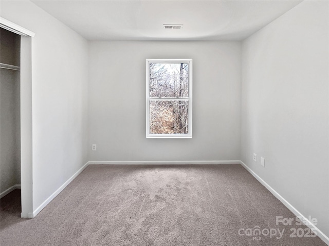 unfurnished bedroom featuring a closet, carpet, visible vents, and baseboards