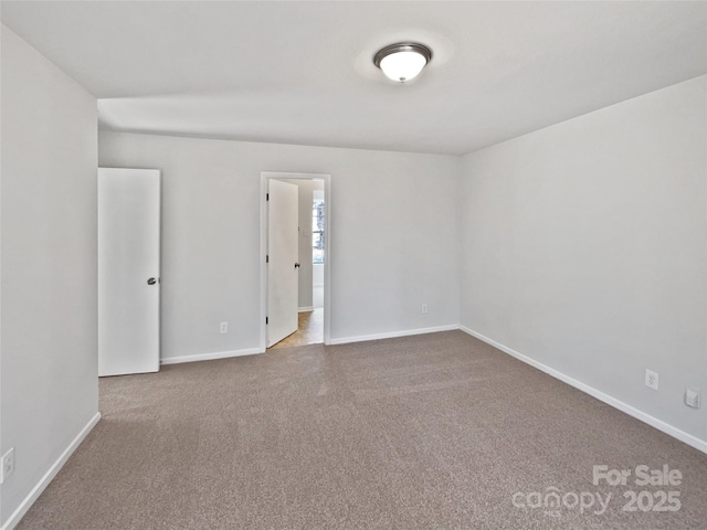 unfurnished room with carpet and baseboards