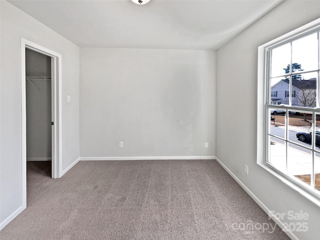 carpeted spare room with a healthy amount of sunlight and baseboards