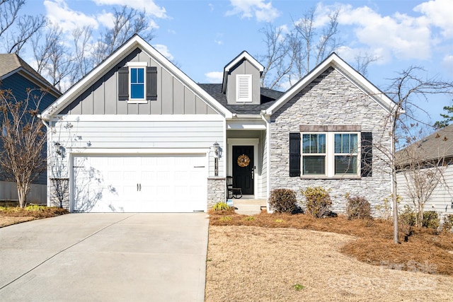 view of front facade featuring board and batten siding, stone siding, driveway, and a garage