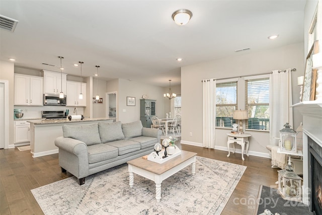 14707 Batteliere Dr, Charlotte, NC 28278 - living room with a fireplace with flush hearth, recessed lighting, visible vents, and a notable chandelier