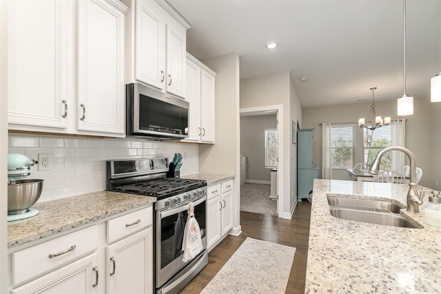 14707 Batteliere Dr, Charlotte, NC 28278 - kitchen featuring pendant lighting, stainless steel appliances, tasteful backsplash, white cabinets, and a sink