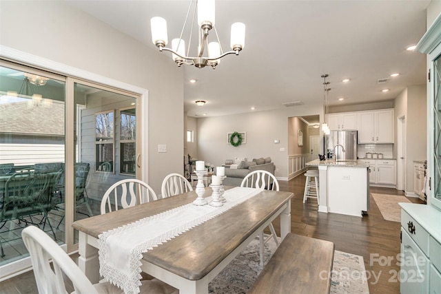 14707 Batteliere Dr, Charlotte, NC 28278 - dining area featuring a notable chandelier, dark wood-style flooring, and recessed lighting