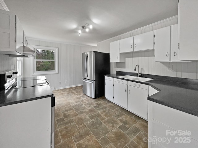 kitchen with range, dark countertops, freestanding refrigerator, white cabinetry, and a sink