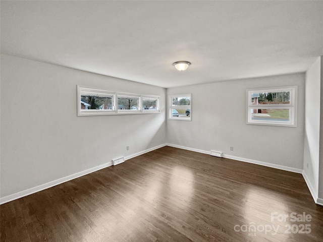 unfurnished room featuring dark wood finished floors and baseboards