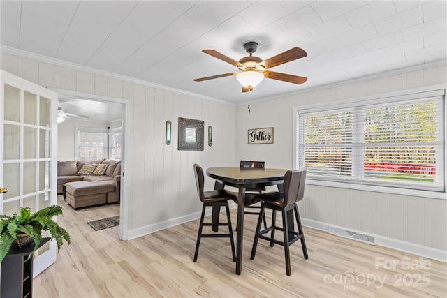 dining area with ceiling fan, light wood finished floors, baseboards, and crown molding