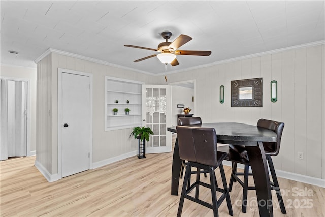 dining space with light wood-style flooring, ornamental molding, and ceiling fan