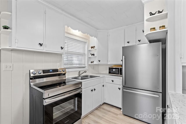 kitchen featuring white cabinets, appliances with stainless steel finishes, light countertops, open shelves, and a sink