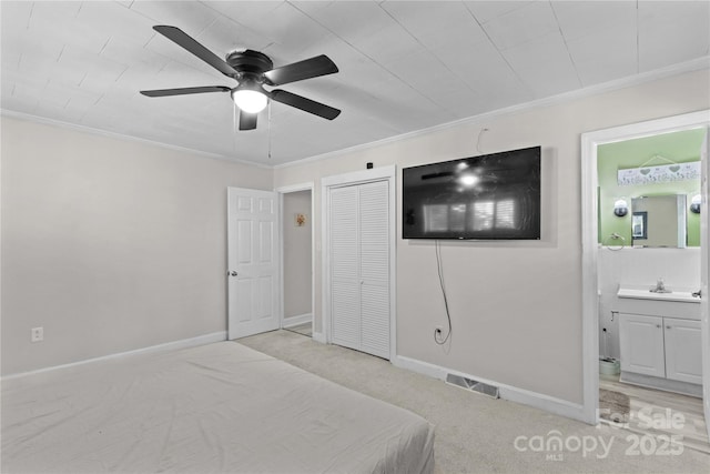 unfurnished bedroom with a closet, visible vents, ornamental molding, ensuite bath, and baseboards