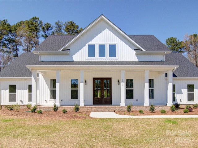 modern farmhouse style home with roof with shingles, french doors, board and batten siding, and a front lawn