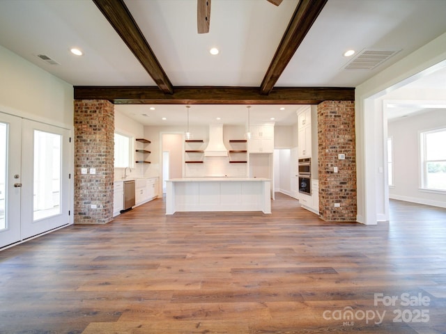 unfurnished living room featuring french doors, dark wood-type flooring, beamed ceiling, and visible vents