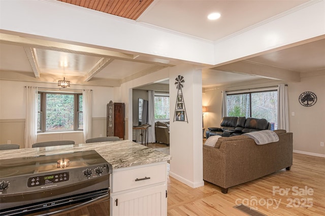 kitchen featuring light wood finished floors, open floor plan, black electric range oven, beamed ceiling, and white cabinetry