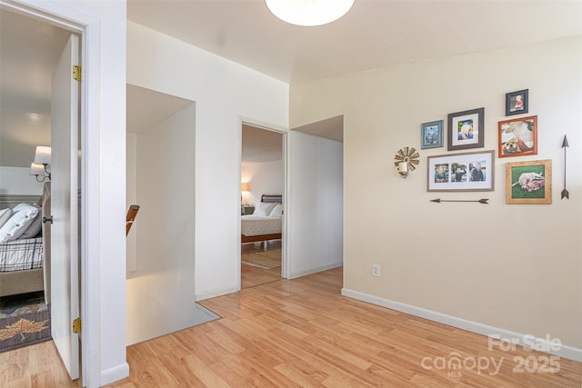 interior space featuring lofted ceiling, baseboards, and wood finished floors