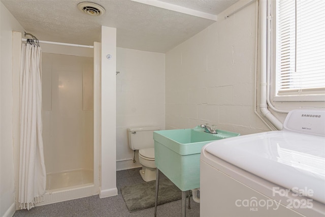 full bath with washer / dryer, a stall shower, visible vents, toilet, and a textured ceiling