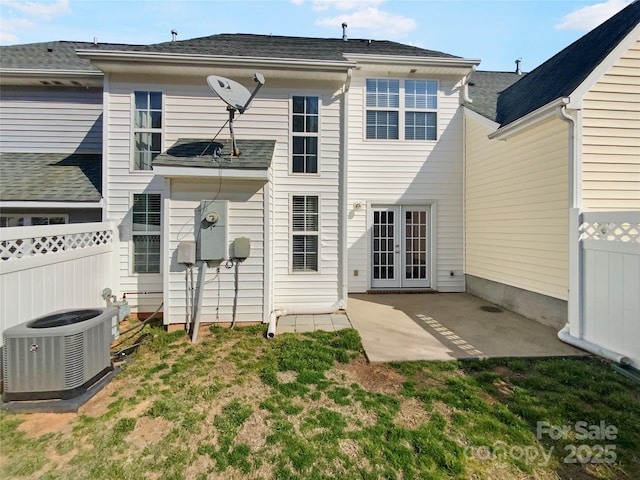 rear view of house with central AC unit, french doors, a patio area, and fence