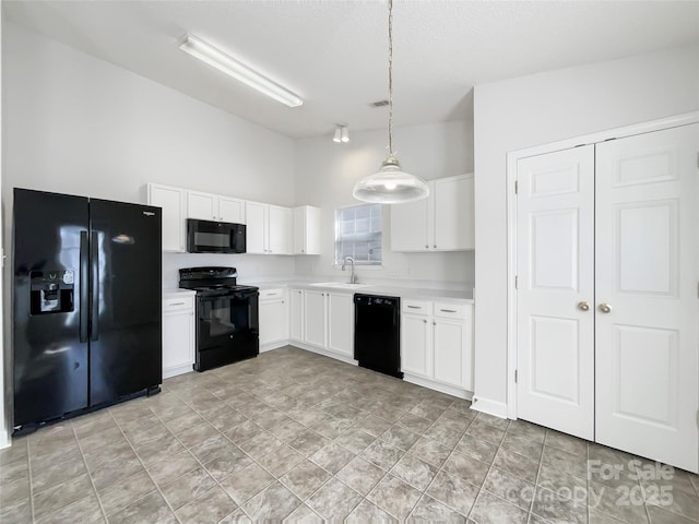 kitchen featuring black appliances, white cabinetry, light countertops, and a sink