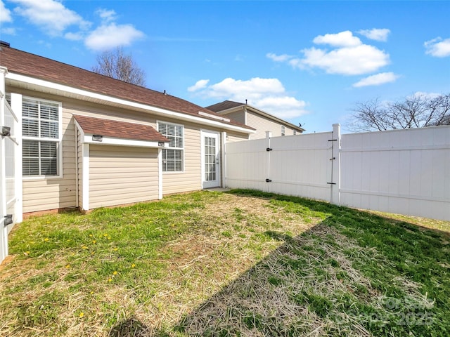 rear view of house with a lawn and fence