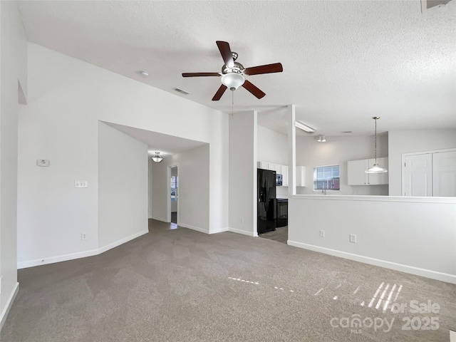 unfurnished living room with lofted ceiling, carpet floors, a textured ceiling, and visible vents