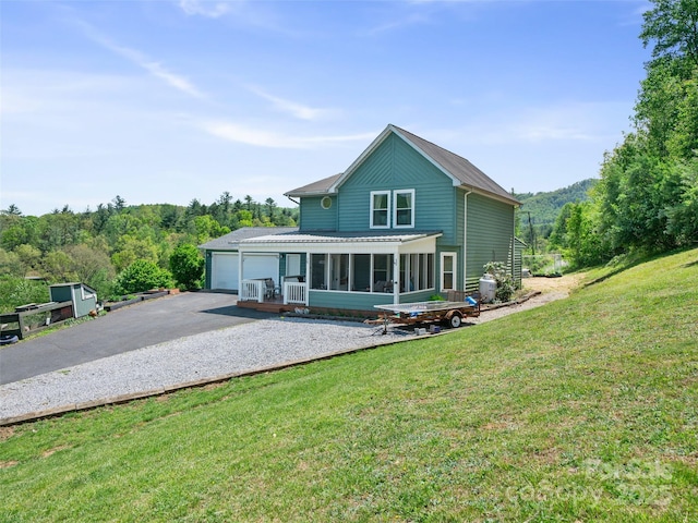 48 Meadowlark Ln, Spruce Pine, NC 28777 - rear view of property with a garage, driveway, a sunroom, and a yard