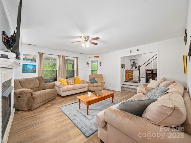 48 Meadowlark Ln, Spruce Pine, NC 28777 - living area featuring ceiling fan, stairs, light wood-style floors, and a tiled fireplace