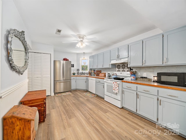 48 Meadowlark Ln, Spruce Pine, NC 28777 - kitchen with white appliances, under cabinet range hood, ceiling fan, light wood-type flooring, and decorative backsplash