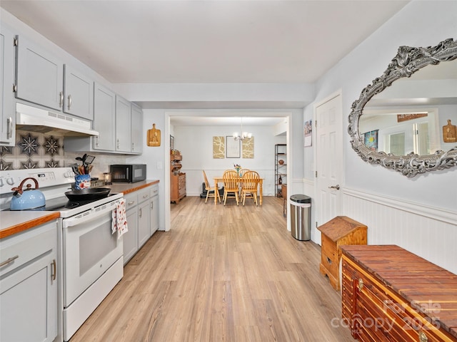 48 Meadowlark Ln, Spruce Pine, NC 28777 - kitchen featuring electric stove, under cabinet range hood, black microwave, decorative backsplash, and light wood-type flooring