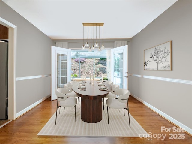 dining space with baseboards and wood finished floors