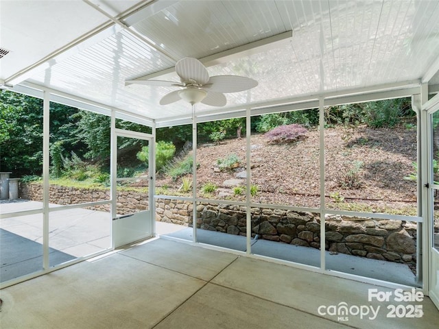 unfurnished sunroom featuring a ceiling fan