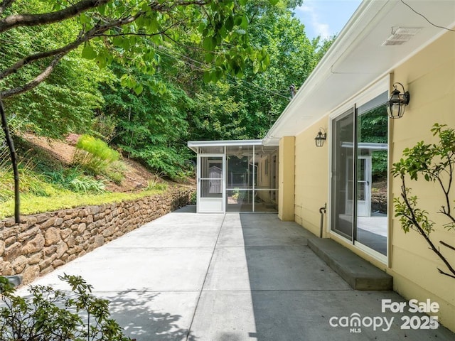 view of patio with a sunroom