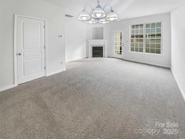 unfurnished living room with a chandelier, carpet, a fireplace with flush hearth, and baseboards