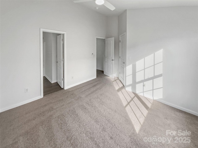 spare room featuring a towering ceiling, ceiling fan, baseboards, and carpet flooring