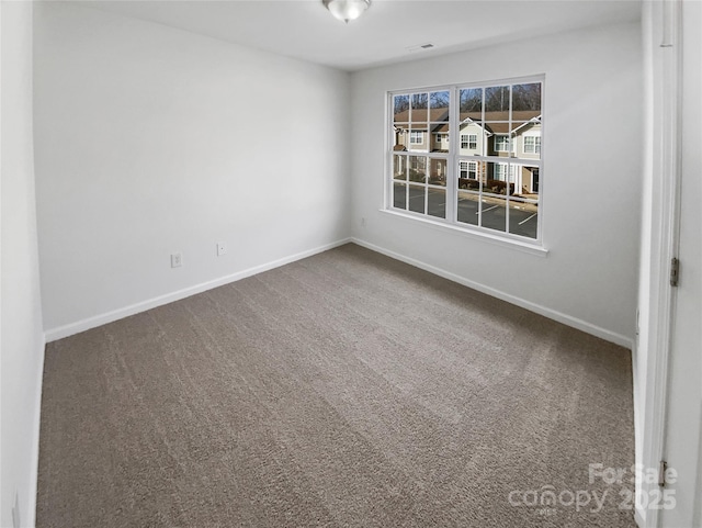 carpeted spare room with visible vents and baseboards