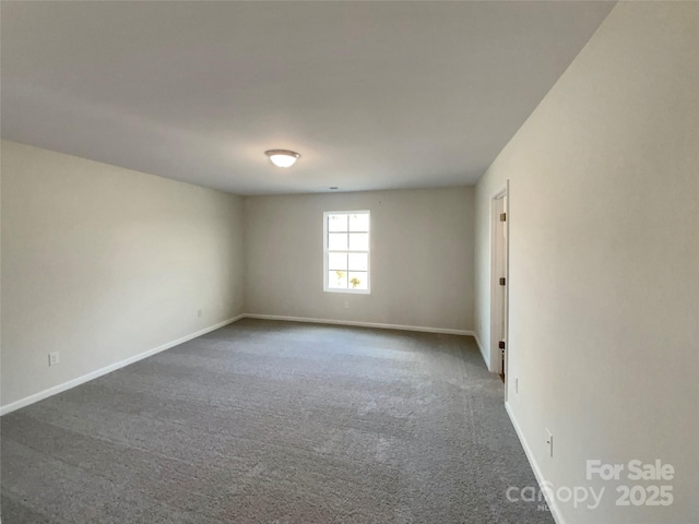 unfurnished room featuring dark carpet and baseboards