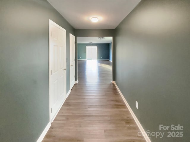 hallway with wood finished floors and baseboards