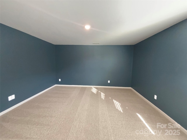 empty room featuring carpet flooring, visible vents, and baseboards