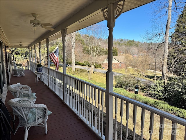 wooden terrace with a ceiling fan and covered porch