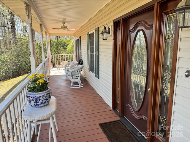 wooden terrace with a porch and a ceiling fan