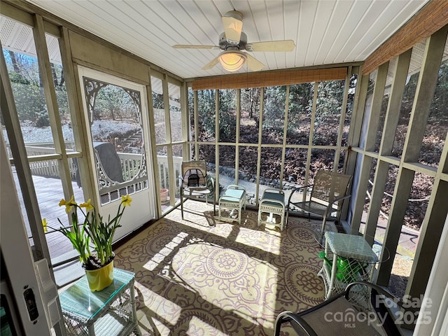 sunroom / solarium featuring a ceiling fan and wooden ceiling