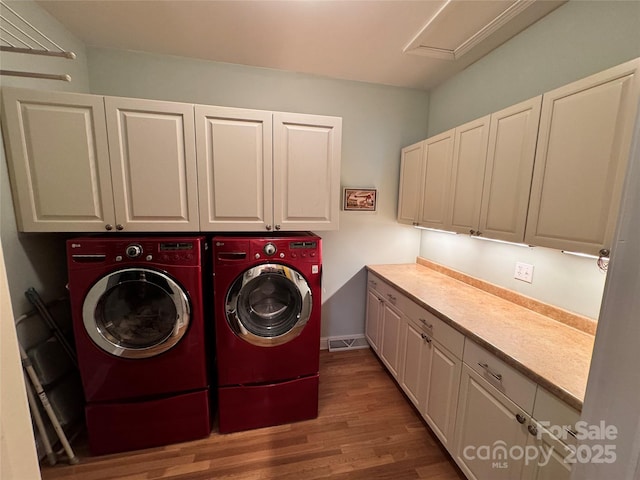 laundry room with attic access, wood finished floors, cabinet space, and separate washer and dryer