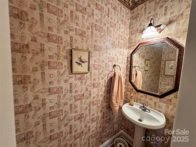 bathroom with a sink and wallpapered walls